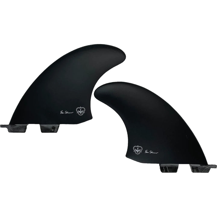 Two black surfboard fins, signed by Ben Skinner, on a white background