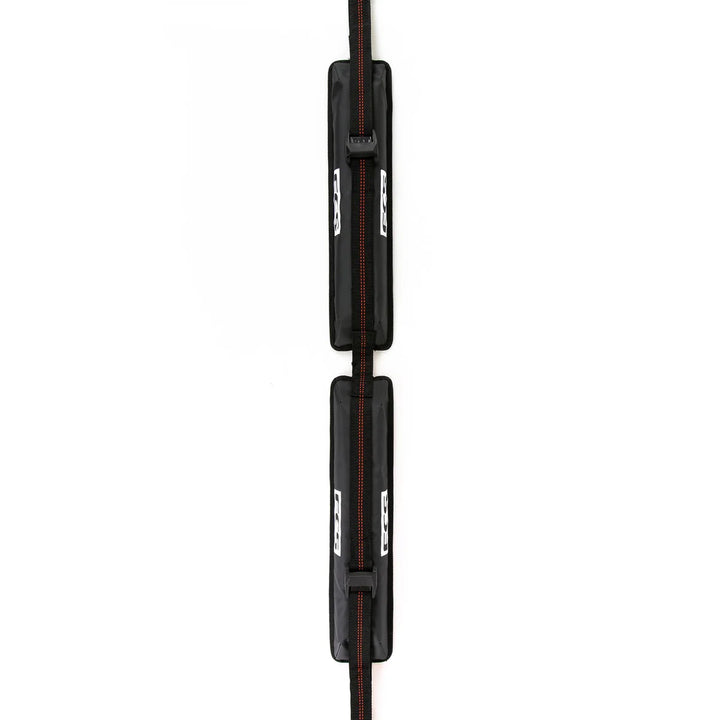 Black soft roof rack for surfboards with red accents on a white background