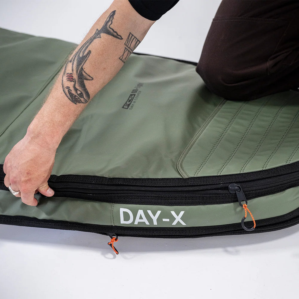 Close-up of the FCS Day-X longboard travel bag in Alpine green, showing zip and expandable gusset.