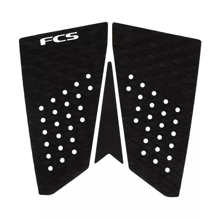 Black FCS surfboard tail pad with geometric patterns on a white background