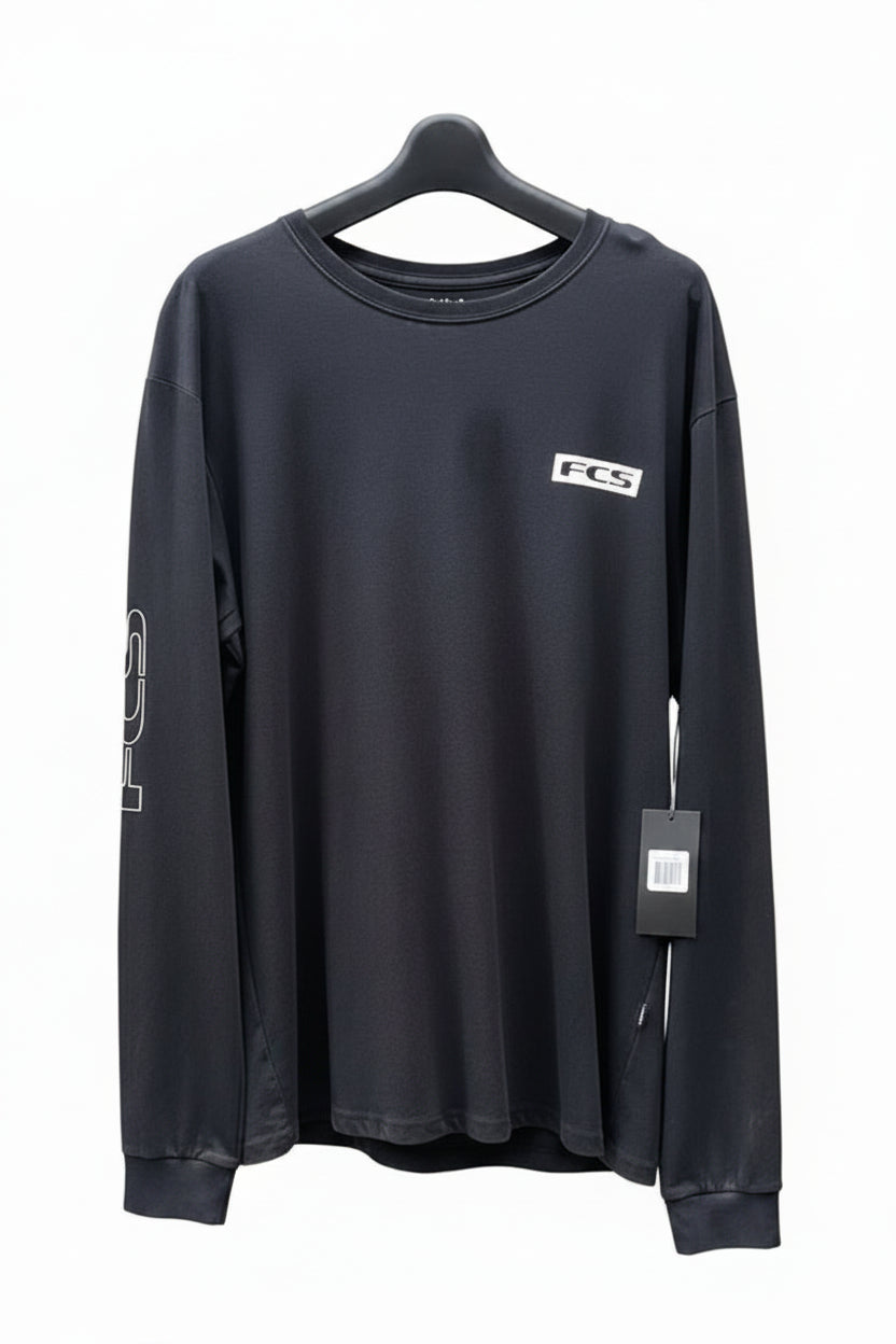 Black long-sleeve shirt with FCS logo on a white surface