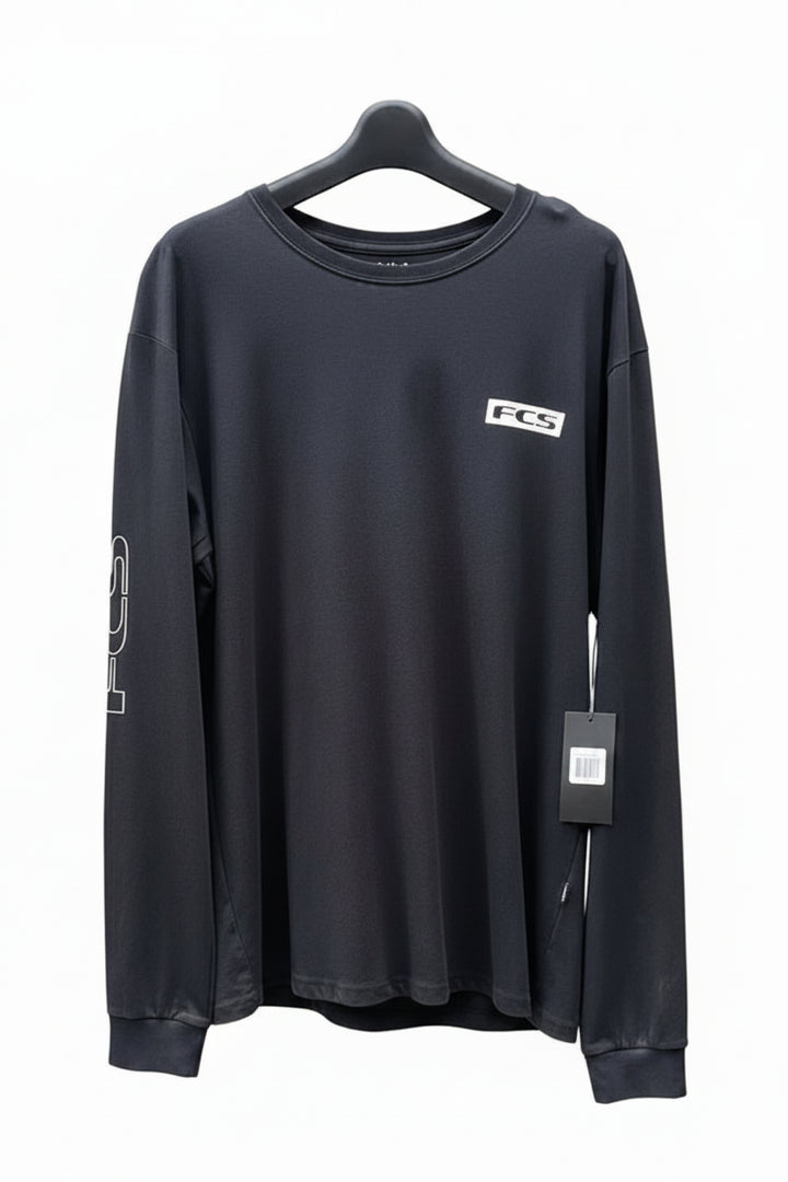 Black long-sleeve shirt with FCS logo on a white surface