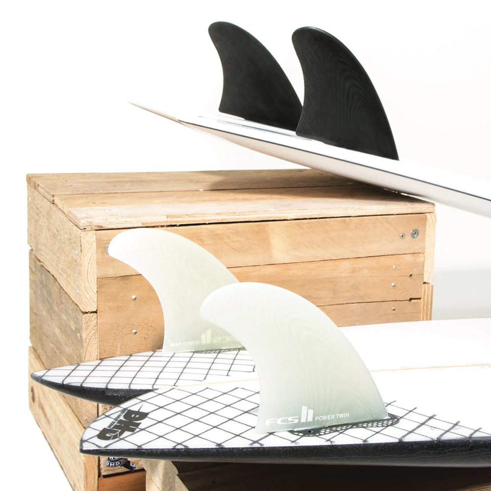 Surfboard with fins on a wooden box and white background
