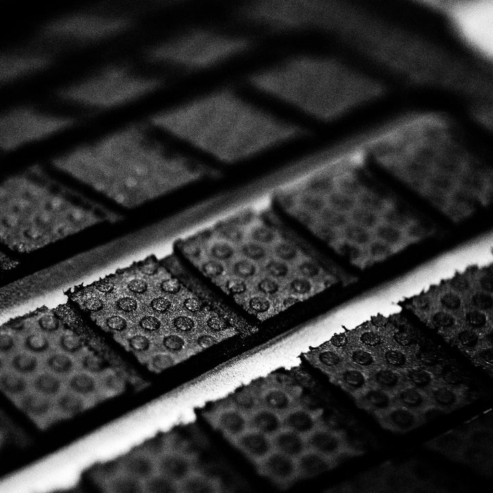 Close-up of black textured tai pad on a white surface