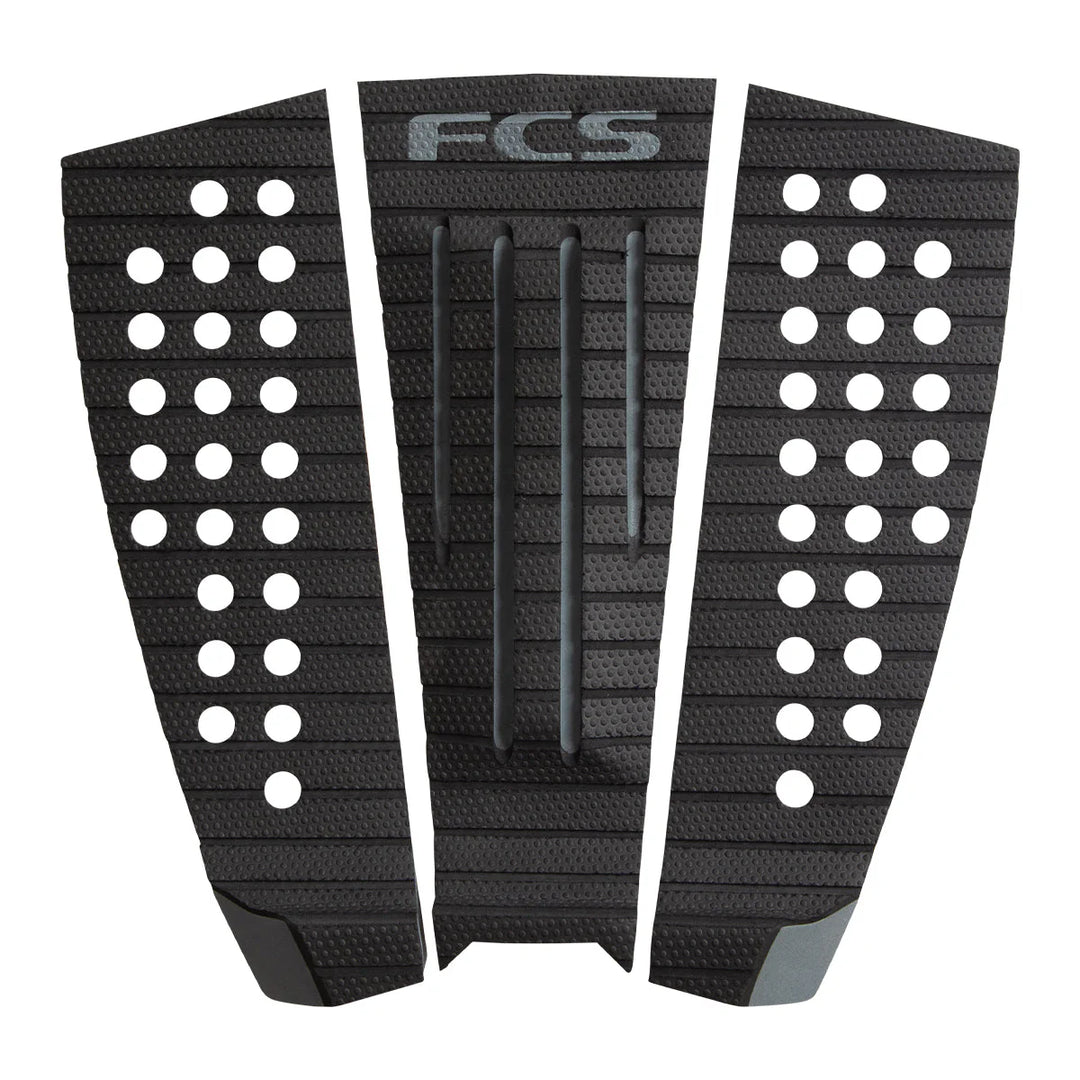 Black FCS surfboard tail pad with patterned design on a white background
