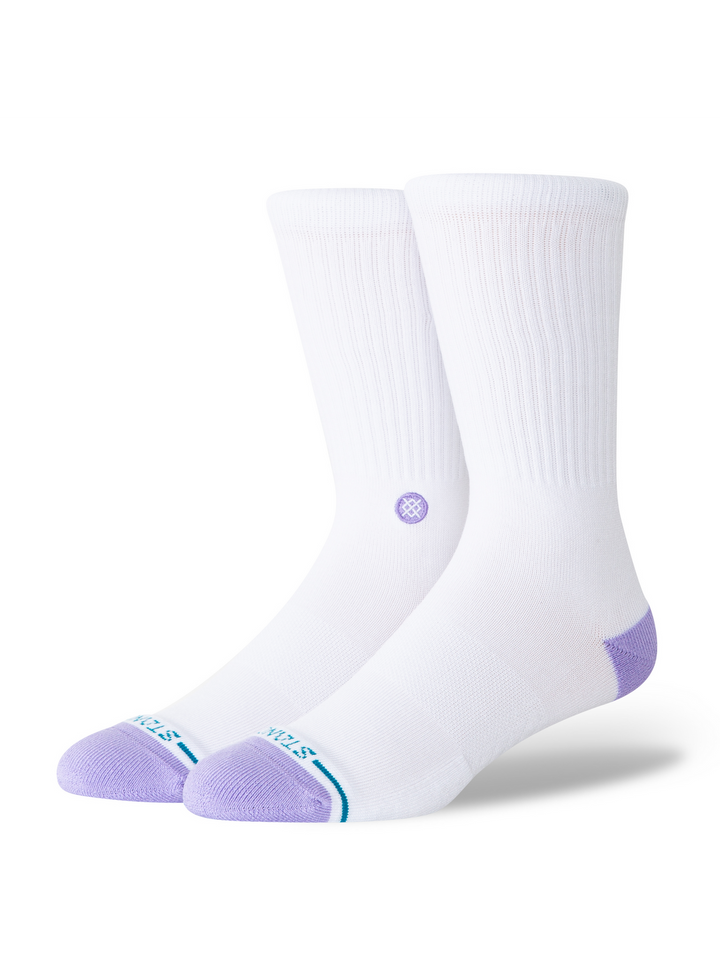 A pair of white crew socks with light purple toes and heels, featuring a small purple circular logo on the side and a thin teal stripe near the toe, shown on a white background.