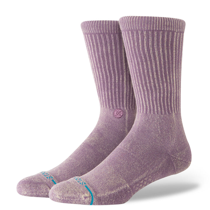 A pair of plum-coloured crew socks with a blue STANCE logo across the toes and circular icon on the inside ankle