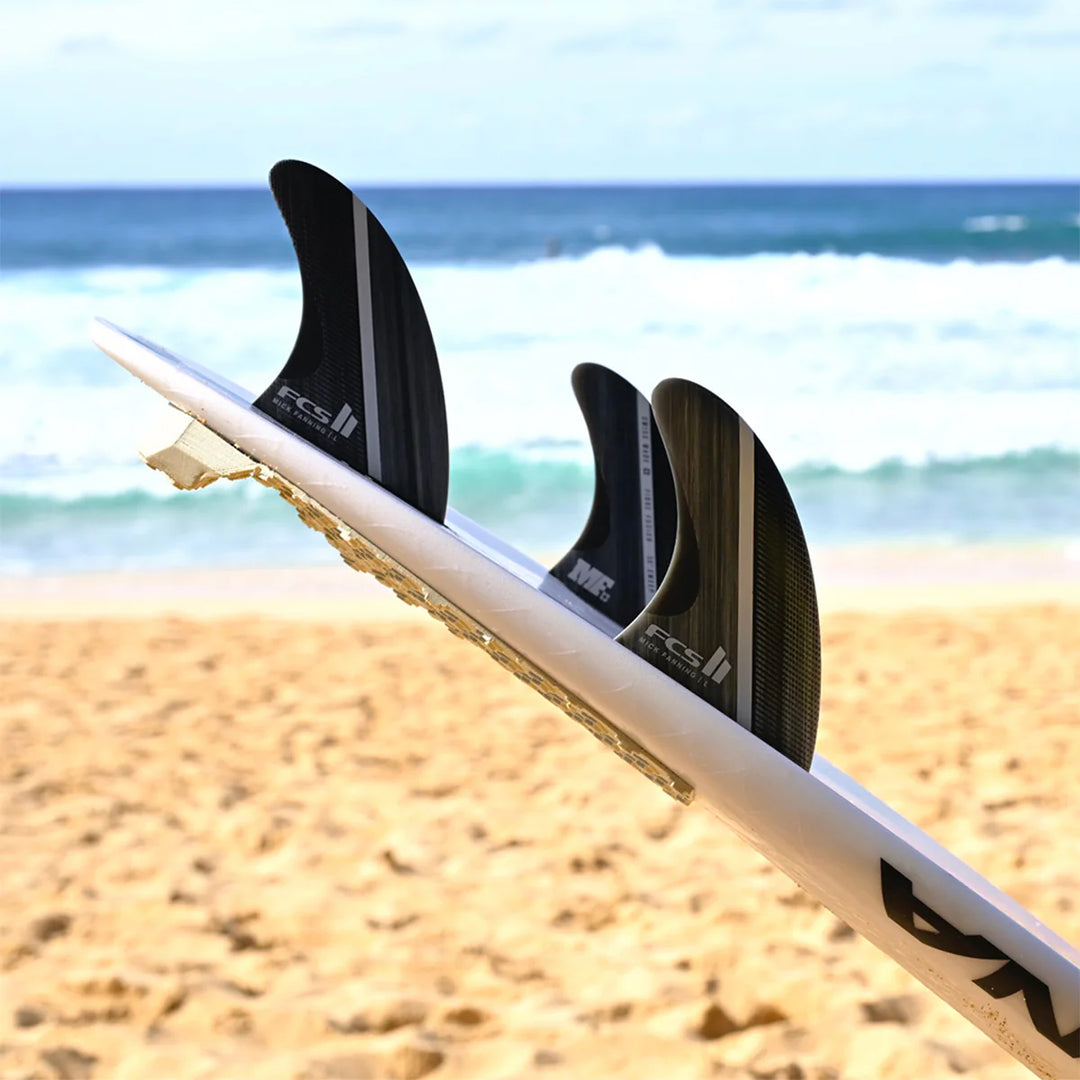Surfboard with fins on a beach