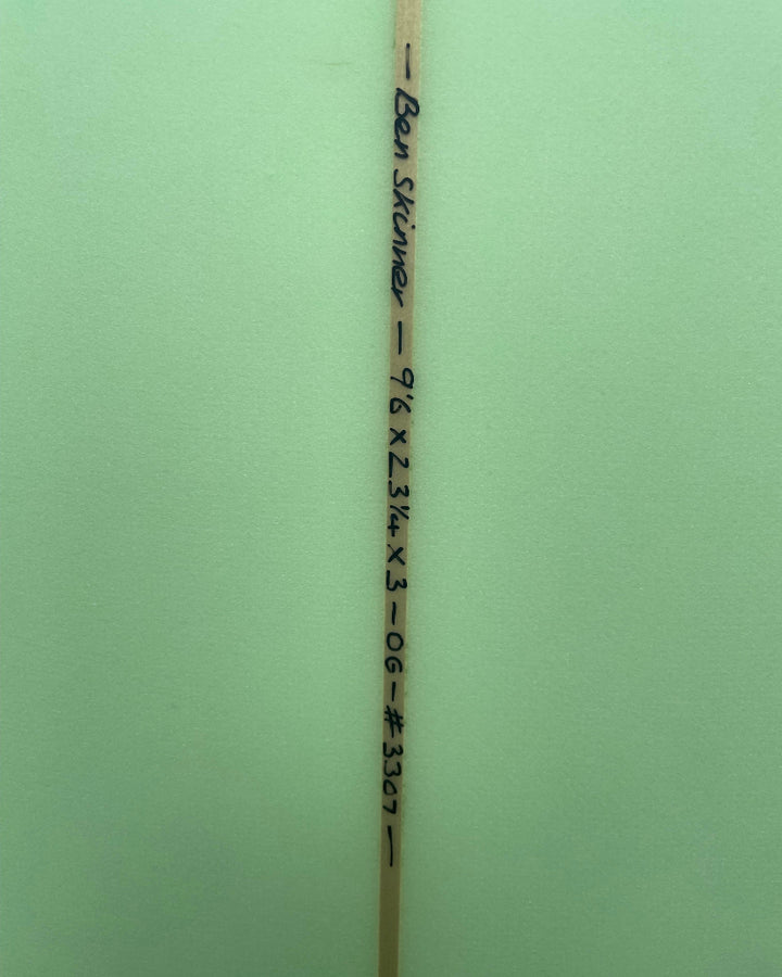 Wooden surfboard stringer with surfboard dimensions written in black