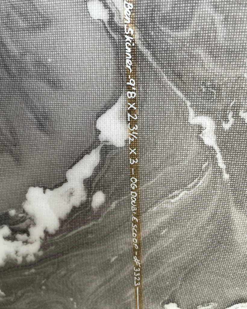 Close-up of surfboard stringer with dimensions written in white