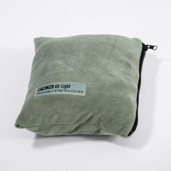 Folded green packable stretch cover with a label on a white background