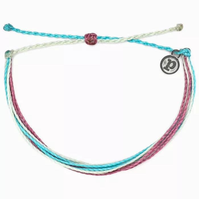 Multicolored braided bracelet with a circular charm on a white background