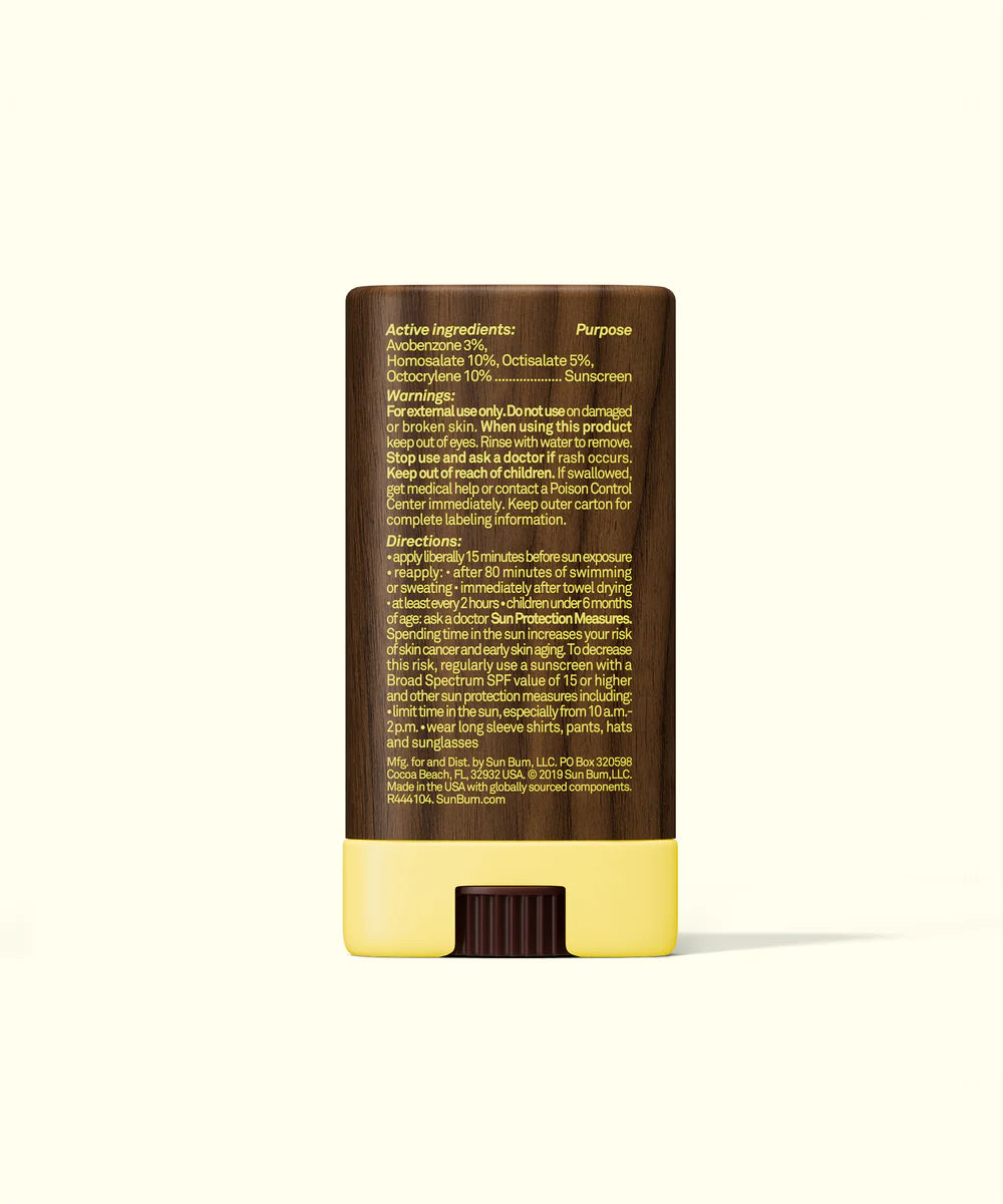 Sunscreen face-stick with brown top and yellow bottom on a white background