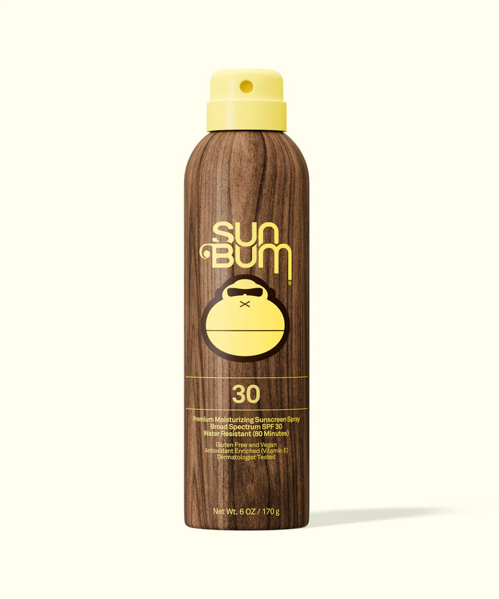 Sun Bum sunscreen spray bottle with wooden texture and yellow cap on a white background