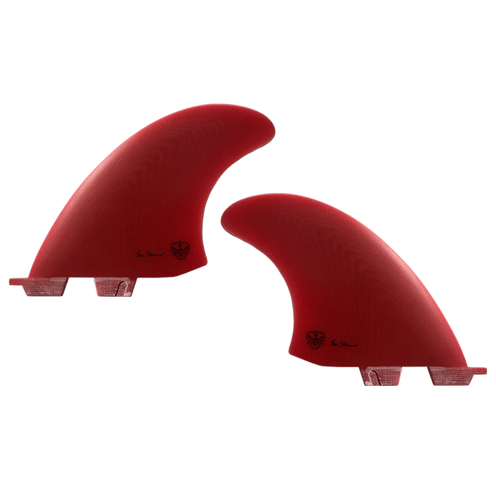 Two red surfboard fins, signed by Ben Skinner, on a white background