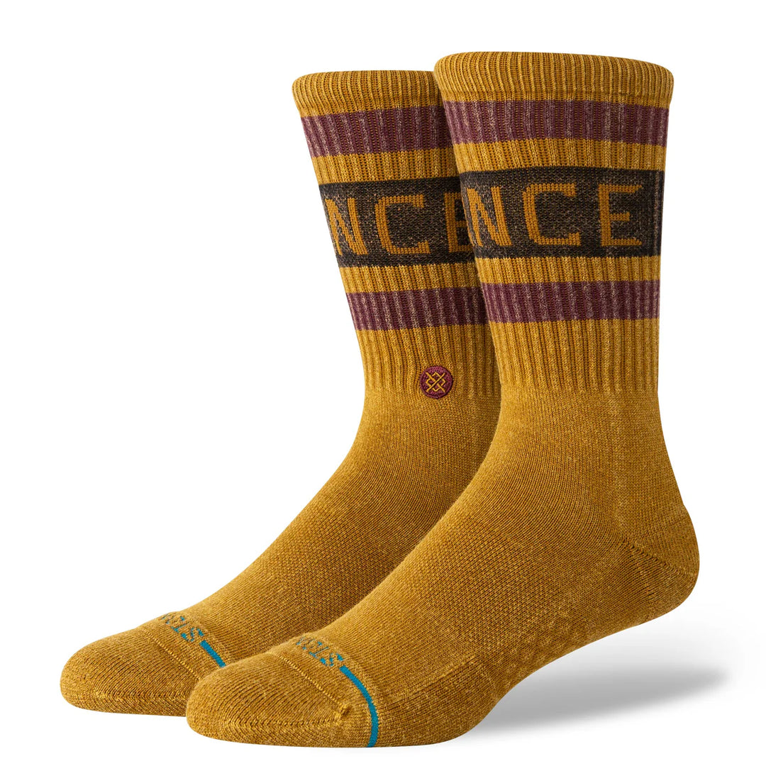 Pair of mustard yellow socks with brown and black stripes on a white background