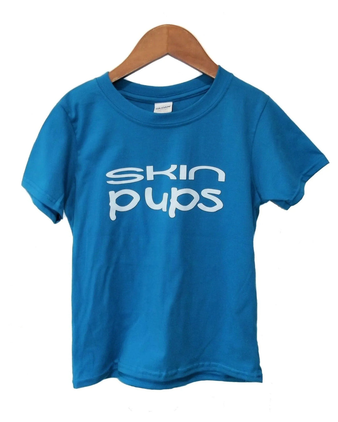 Blue t-shirt with 'skin pups' text on a wooden hanger against a white background