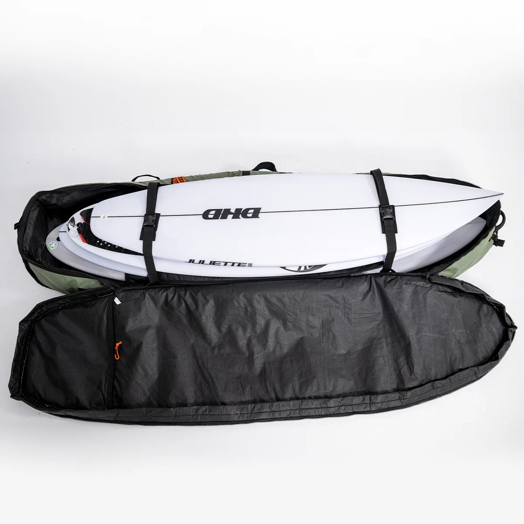 Open FCS travel cover showing stacked surfboards secured with internal straps and the black interior lining.
