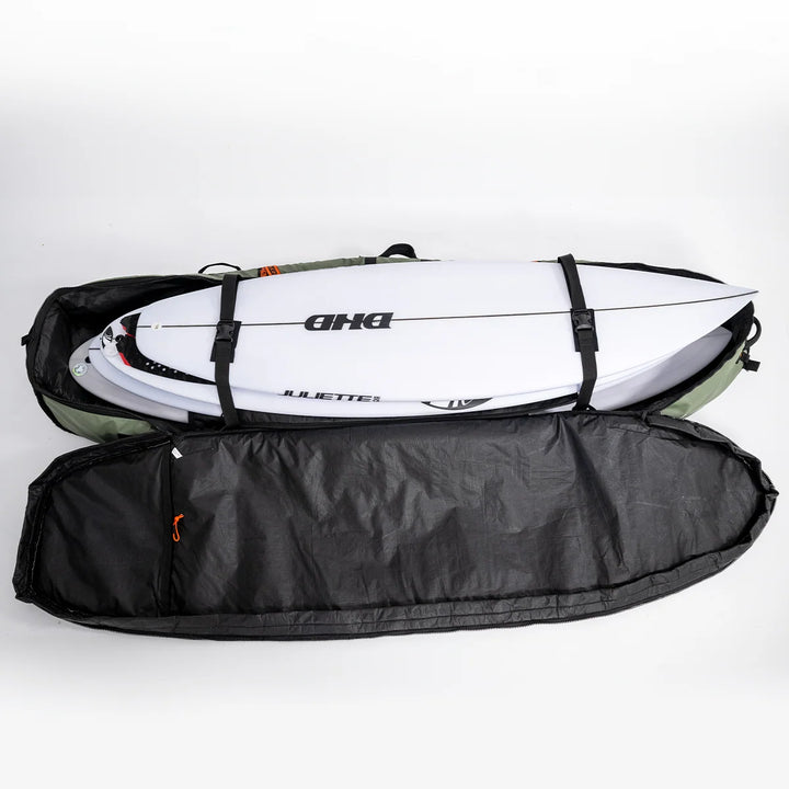 Open FCS travel cover showing stacked surfboards secured with internal straps and the black interior lining.
