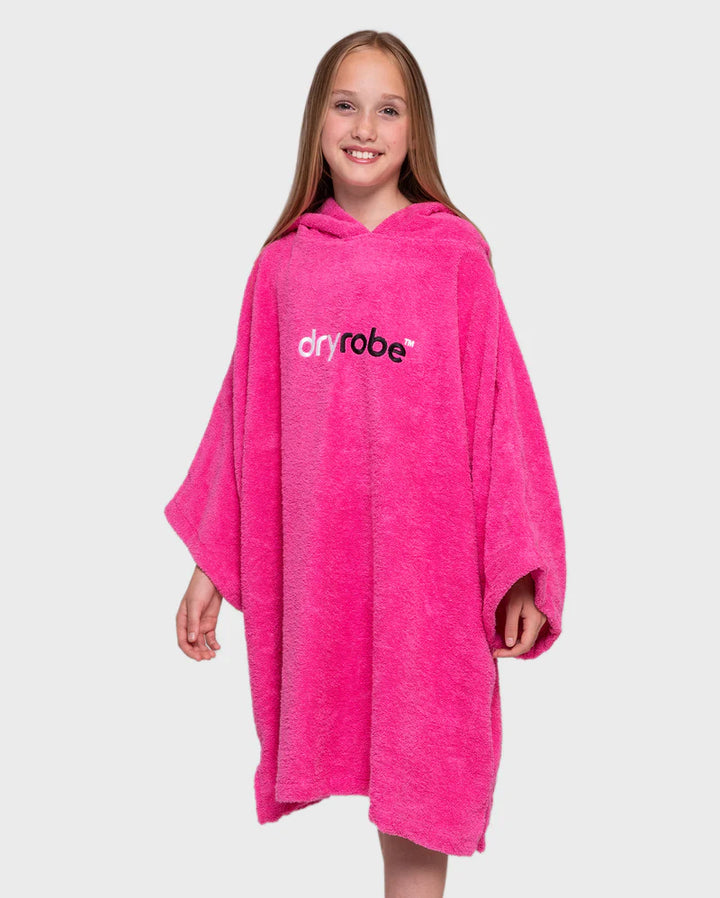 Girl wearing a pink dryrobe on a white background